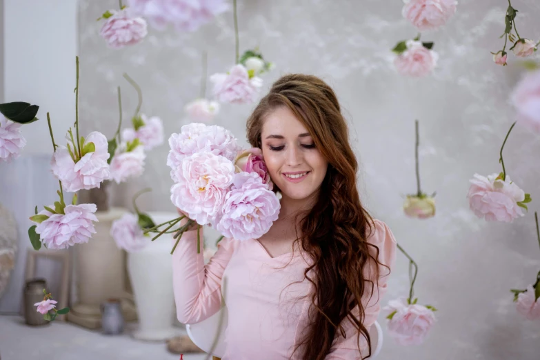 a young woman in a pink dress with flowers on the wall