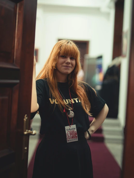 a woman in black and white t - shirt standing inside an opening