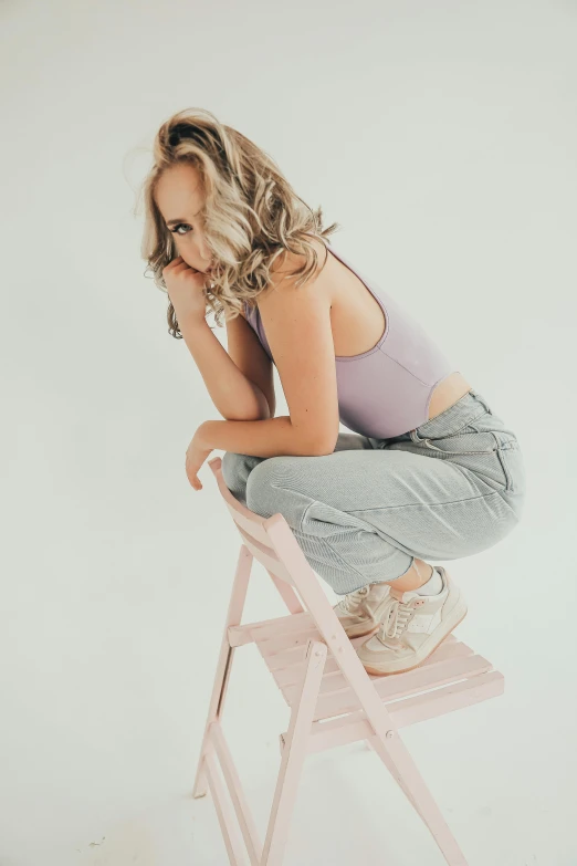 a woman squatting on a stool looking down