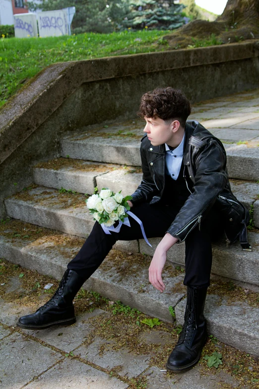 a man in a suit and tie sits on stairs