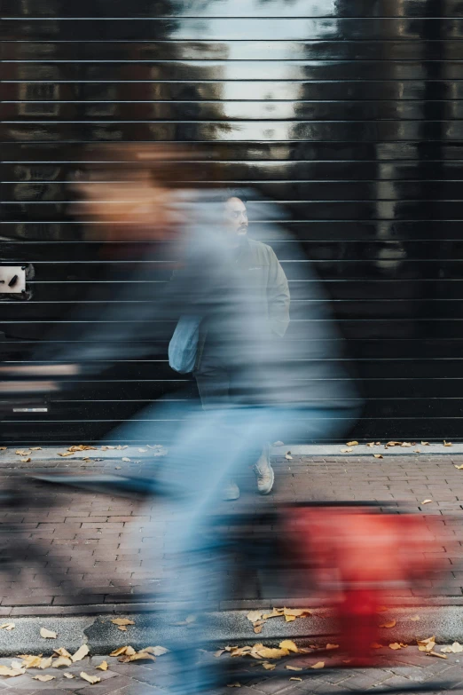 blurred pograph of a man riding a bike near a red fire hydrant