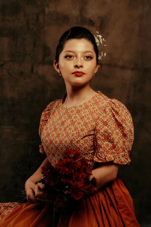 woman in an orange dress holds a bunch of flowers