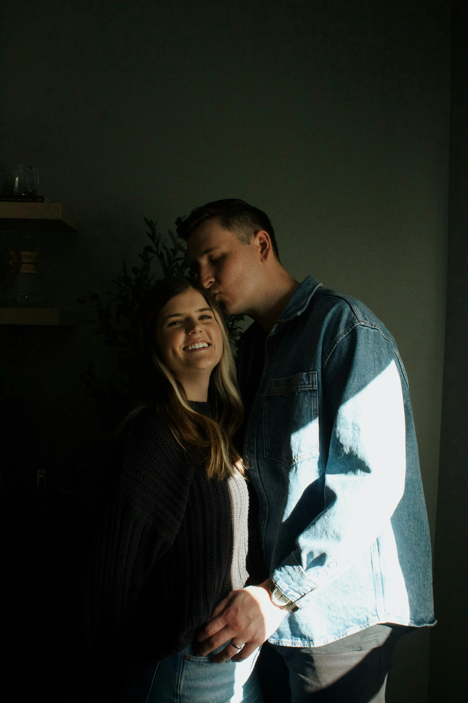 a man and woman are standing in front of a wall