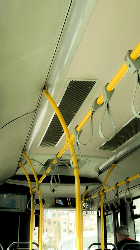 an empty bus has yellow caution lines on the seats