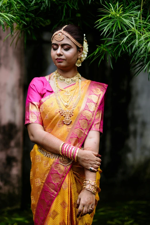 a young indian woman wearing an orange and pink traditional attire