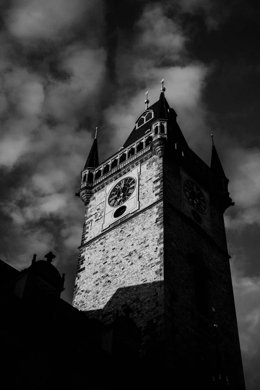 a clock tower stands against a cloudy sky