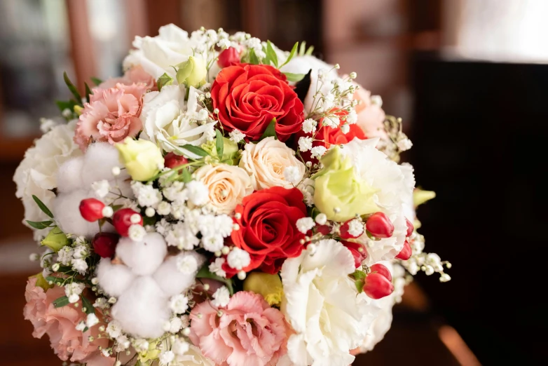 a white and red bouquet is on a table