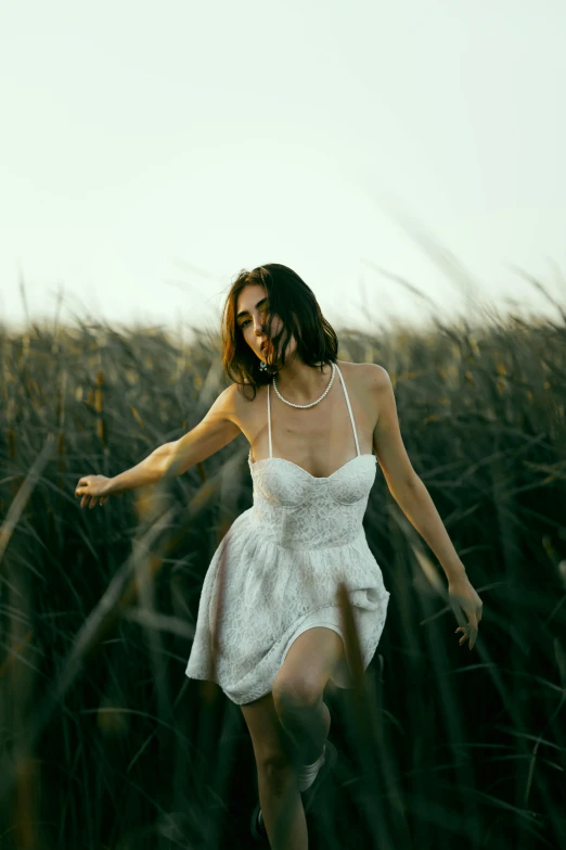 an attractive woman in a white dress poses for the camera