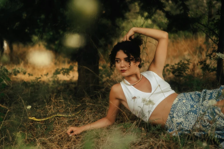 a woman laying on the ground near a tree