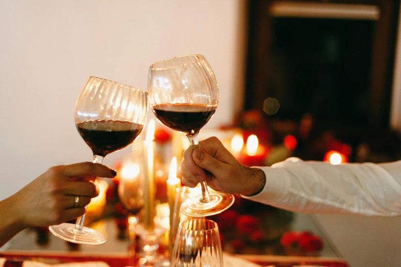 two men hold their glasses of wine near each other