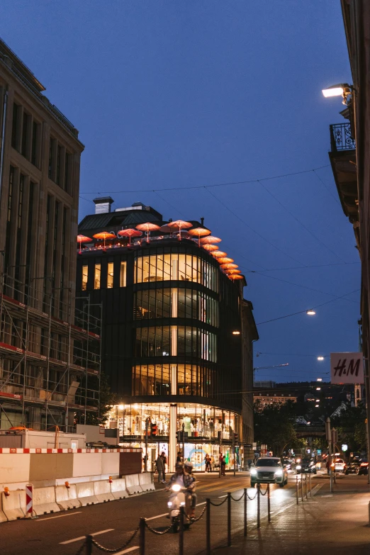 buildings lit up in the evening near a street