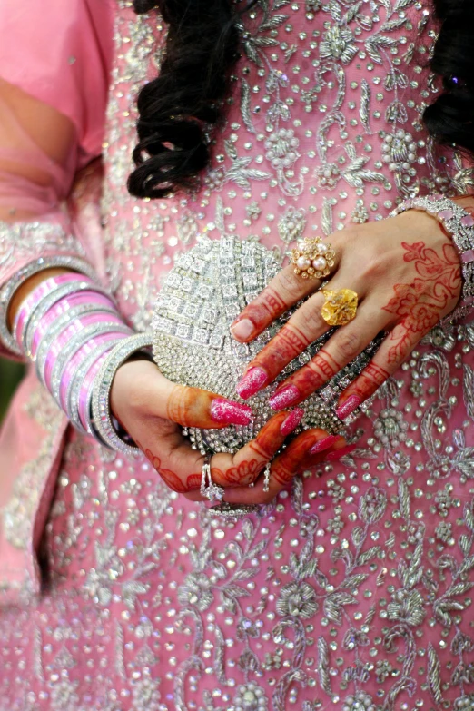 hands with various colored nails and jewelry holding the wrist of a woman