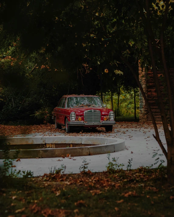 an old car in a lot near some trees