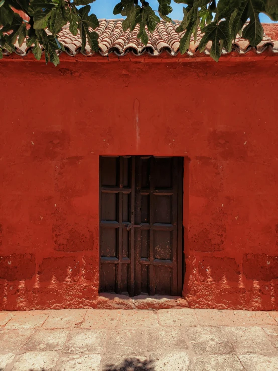 there is a wooden door next to a red wall