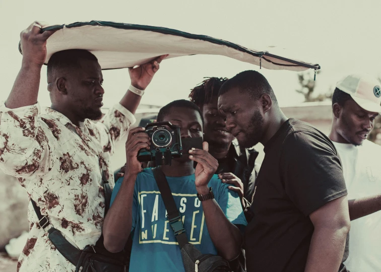 a group of people stand around taking pictures with camera