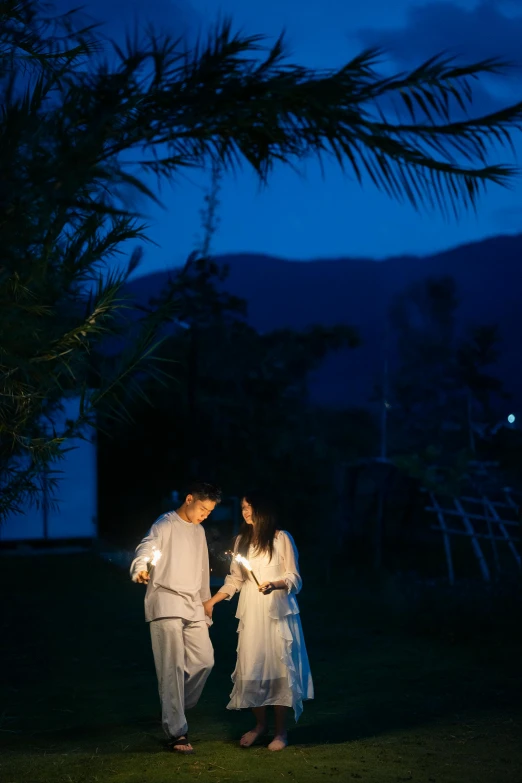 a man and woman standing on top of a lush green field