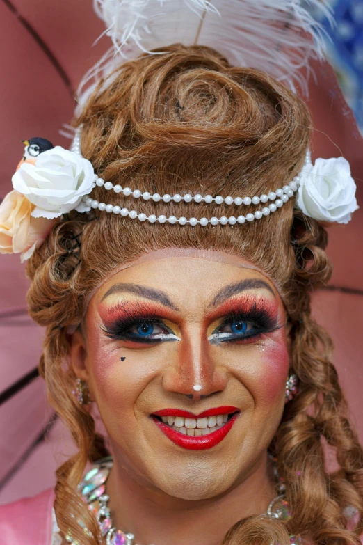 a smiling woman with her face painted like a queen