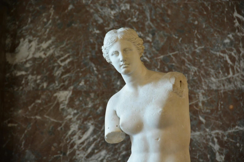 a statue of a woman standing in front of a wall