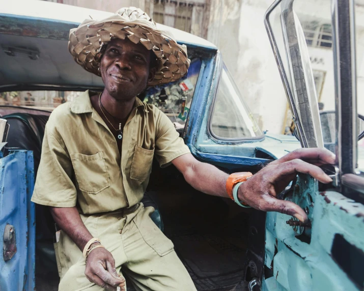 man in a straw hat in an old truck