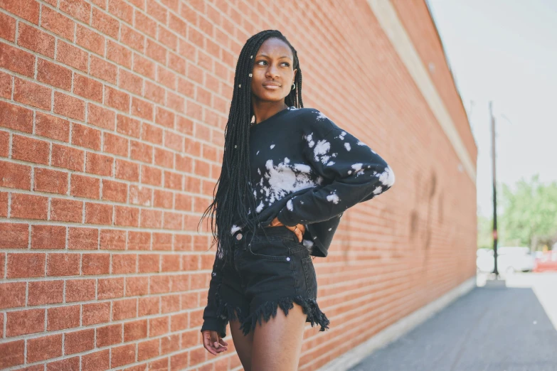 an african american woman standing against a brick wall