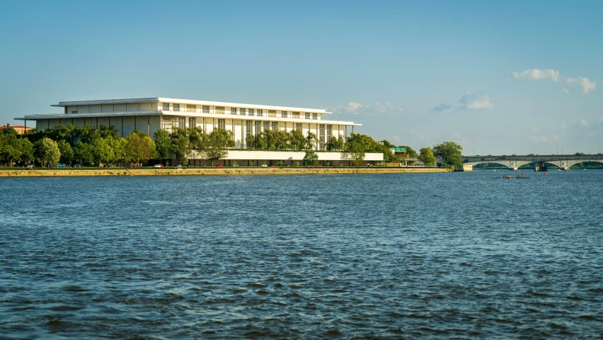 large white building sitting next to the water