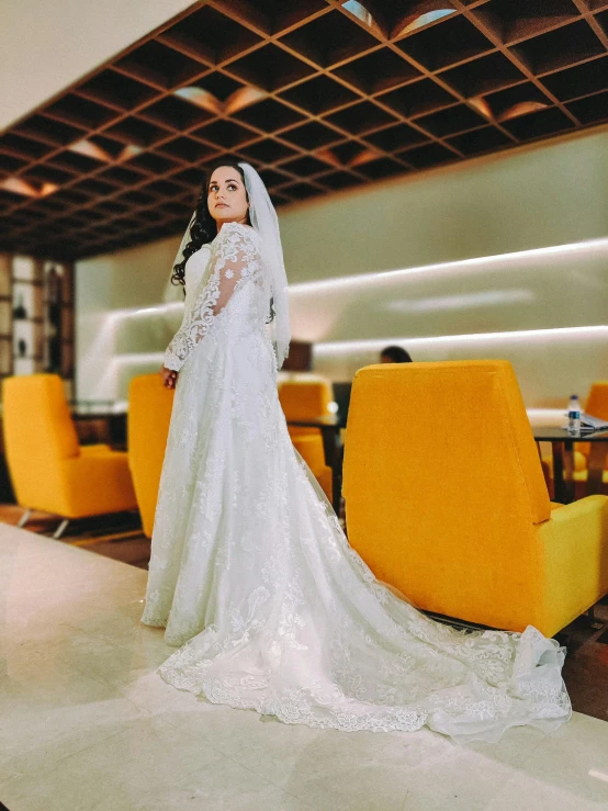 bride posing in her gown and veil in an airy and modern space