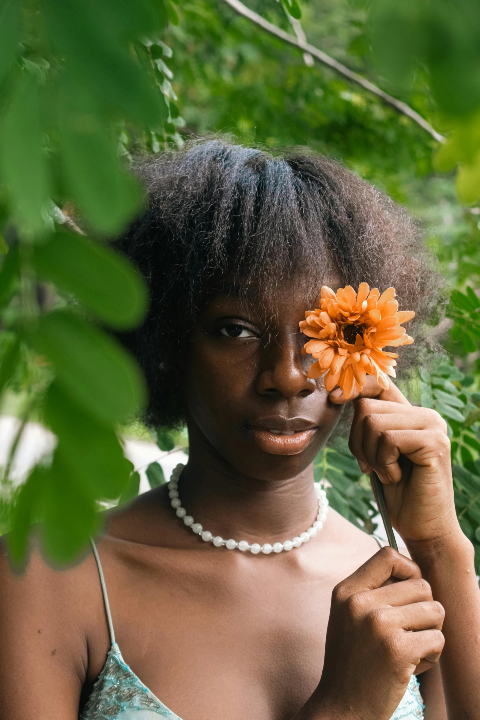 a woman holds a flower in her left hand