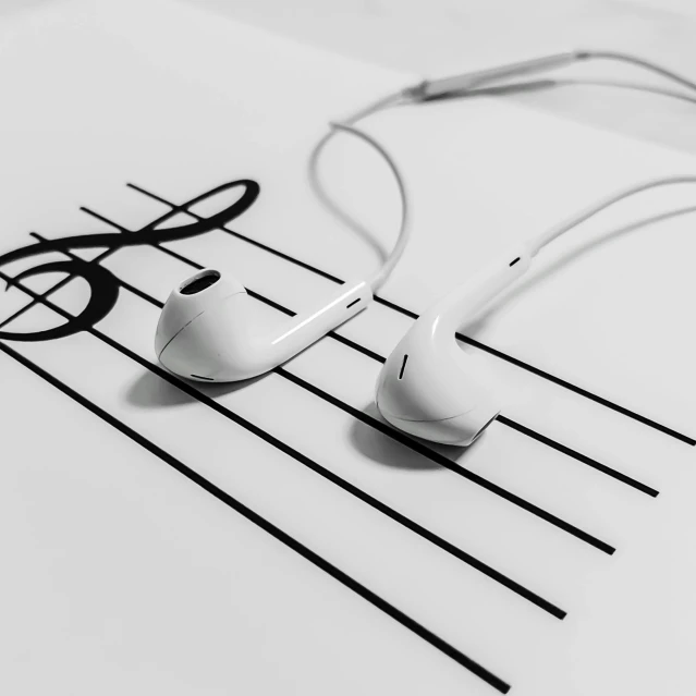 an image of music with ear buds placed on a white sheet