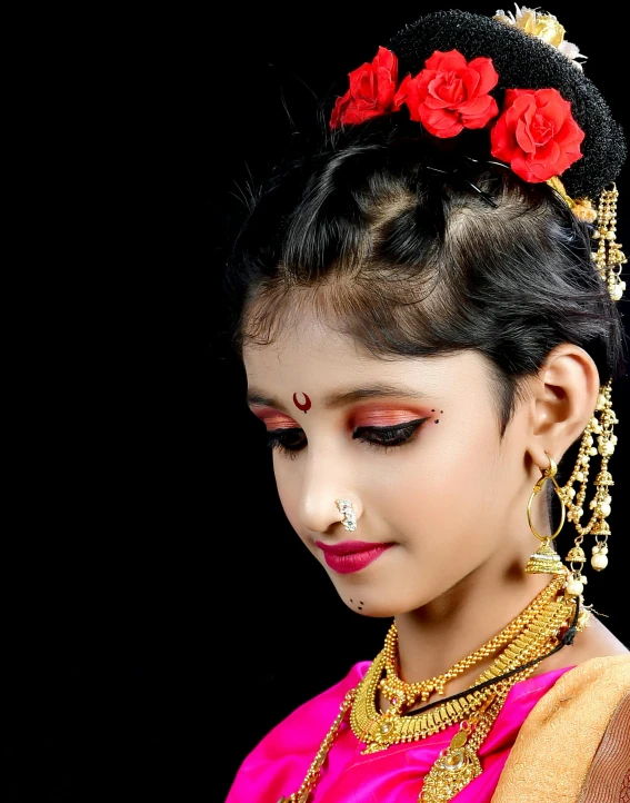 a woman in a traditional indian dress with a red rose on her head