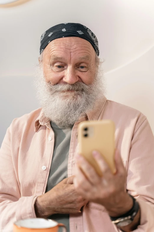 a man with a white beard is looking at his phone