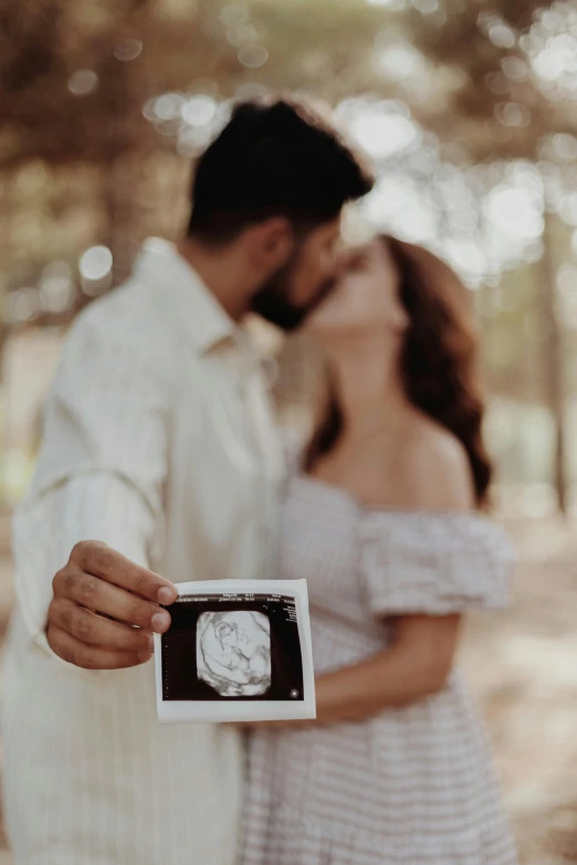 a couple holds a picture of a baby in it