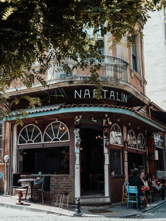 people sitting on chairs outside the tavern called nabatin