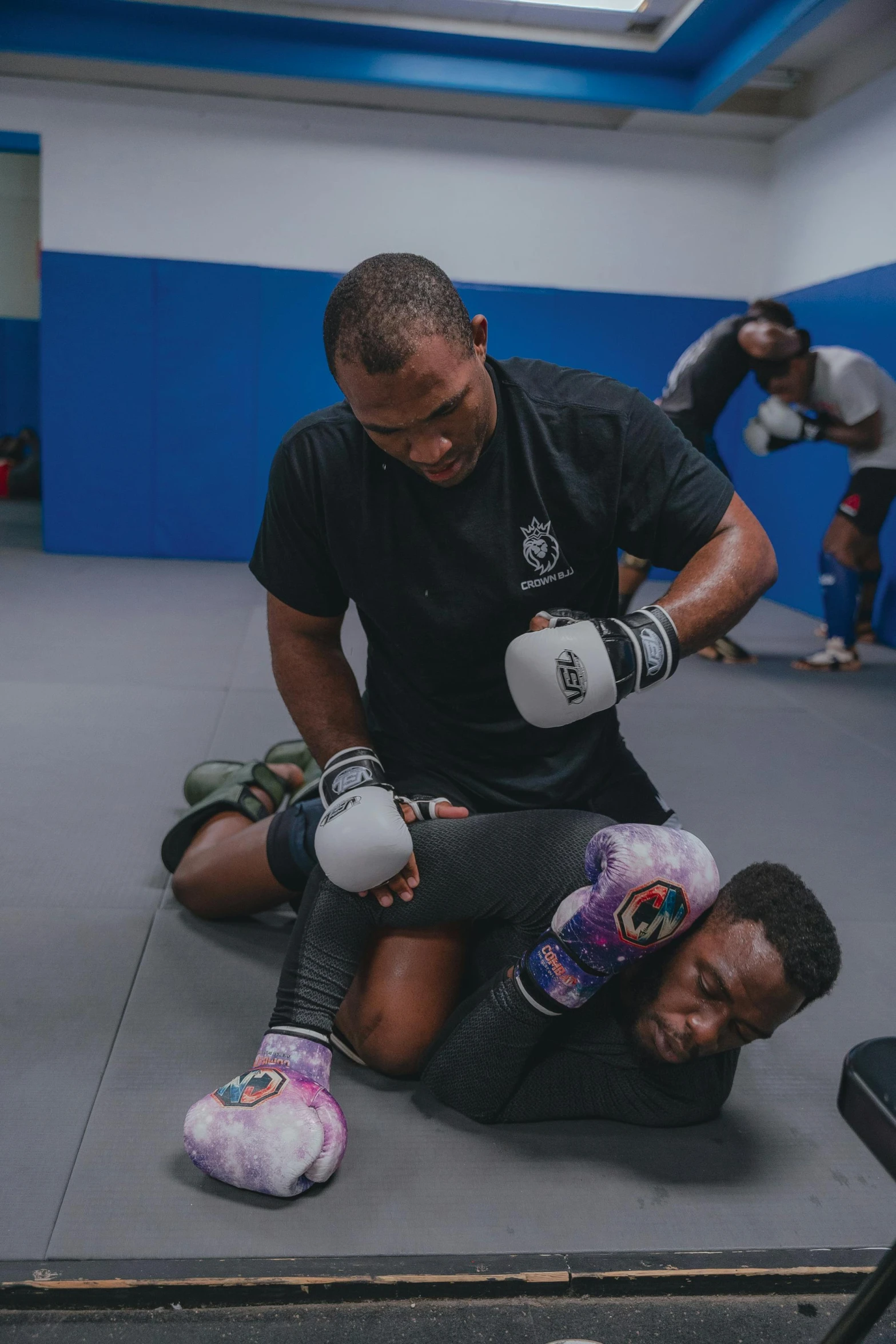 a man holding onto another man with boxing gloves on