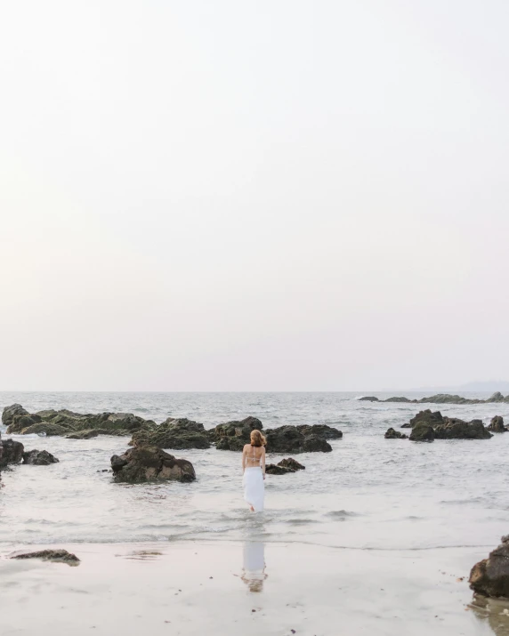 the woman is standing alone by the ocean shore