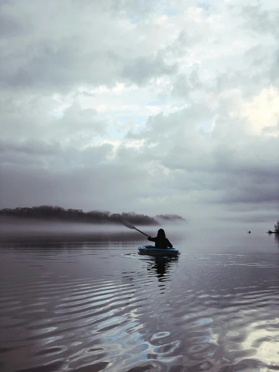 a person sitting in the water paddling a kayak