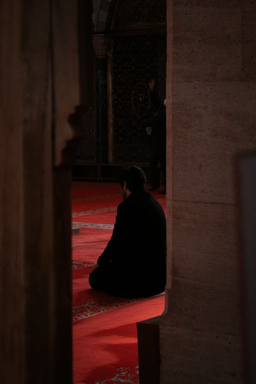 a man sitting on a floor on top of a rug