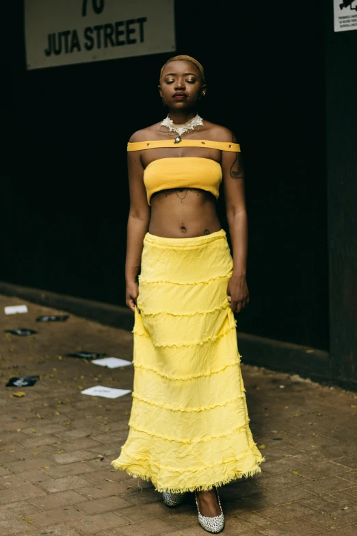 a woman in a yellow outfit walking on the street