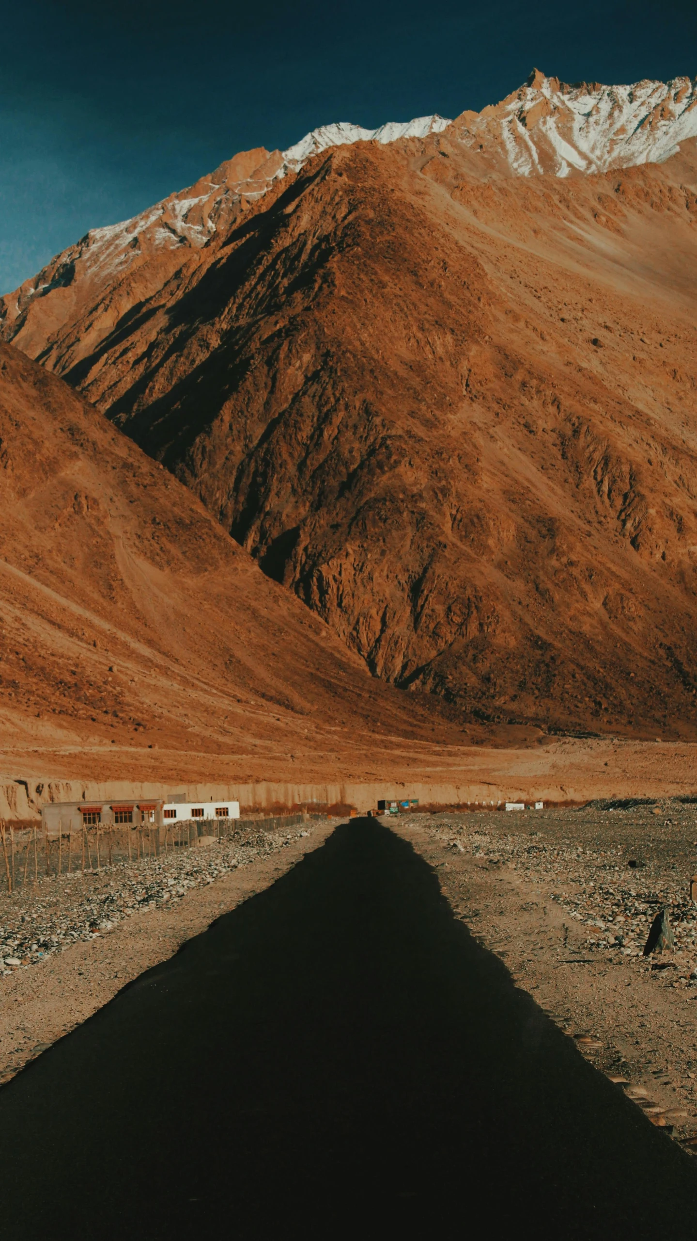 a mountain is behind a road in the desert