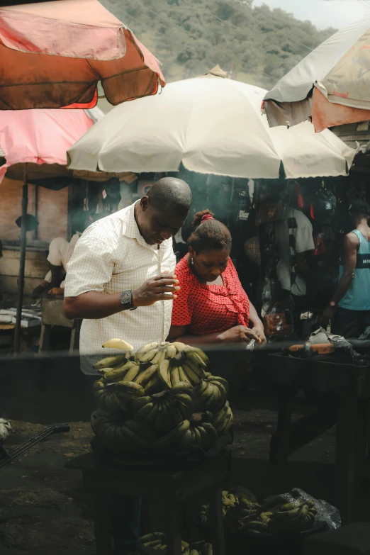 a man standing behind a woman at an outdoor market