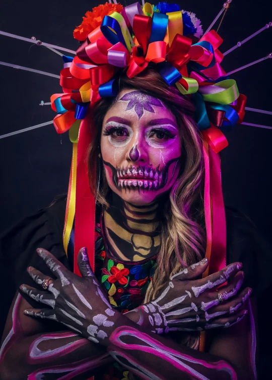 a woman in skeleton paint holding hands up to her face