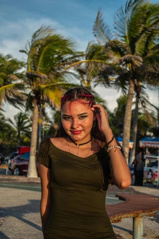 a woman posing for a po in front of palm trees