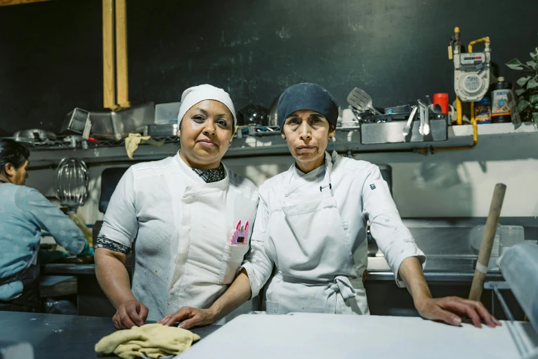 two chefs posing for a picture in the kitchen