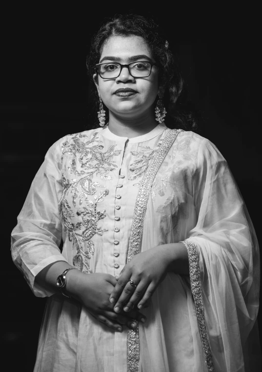 a woman wearing glasses is posing for the camera