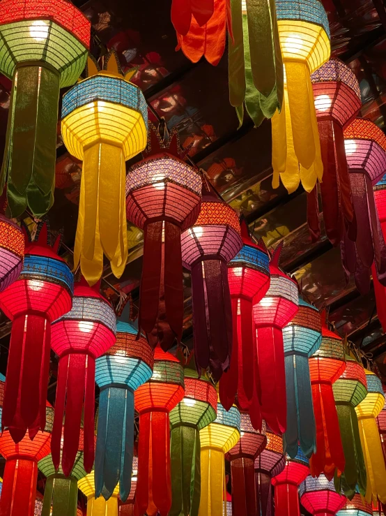 many small colorful lanterns hanging above a crowd