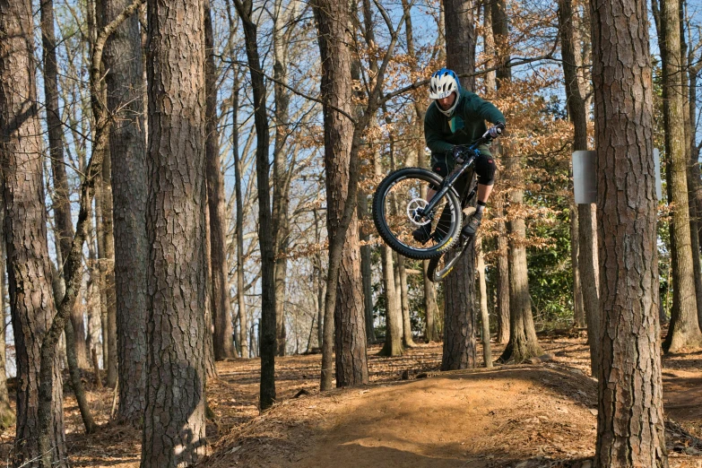 a person is jumping on their mountain bike in the air