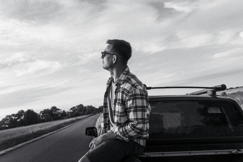 man sitting on the hood of a pickup truck