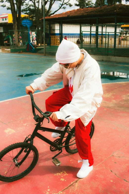 person wearing white hat with bicycle on ramp