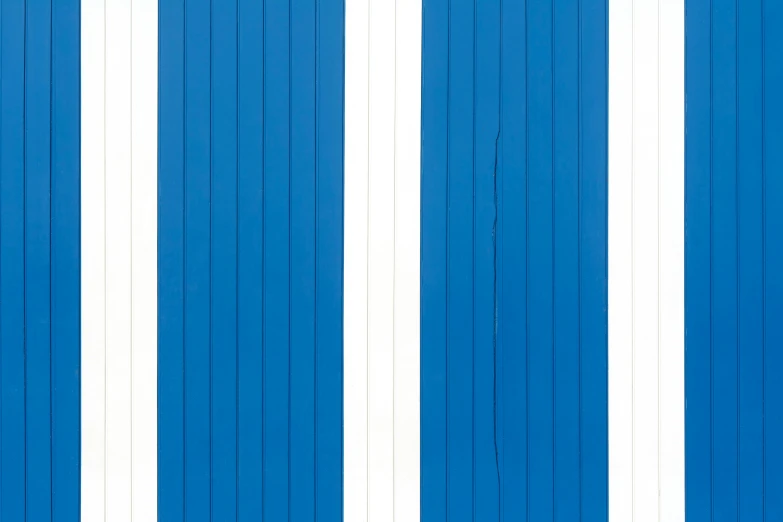 two boards are leaning against a wall with blue doors