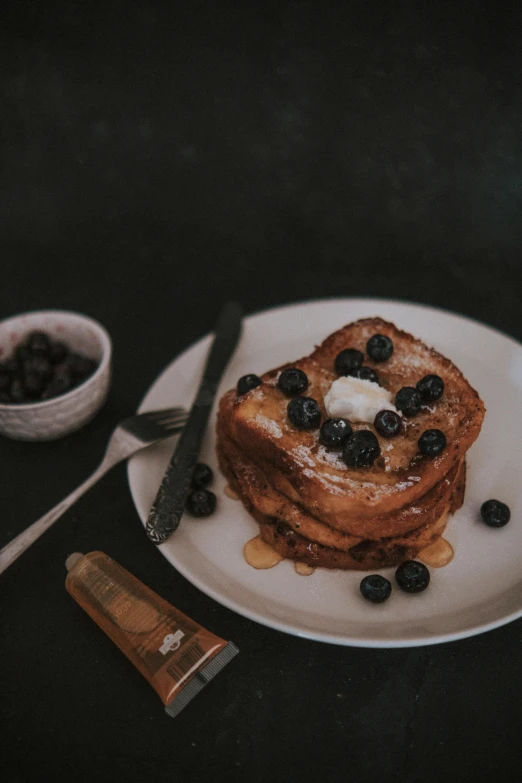 breakfast items displayed on black surface with knife and spoon