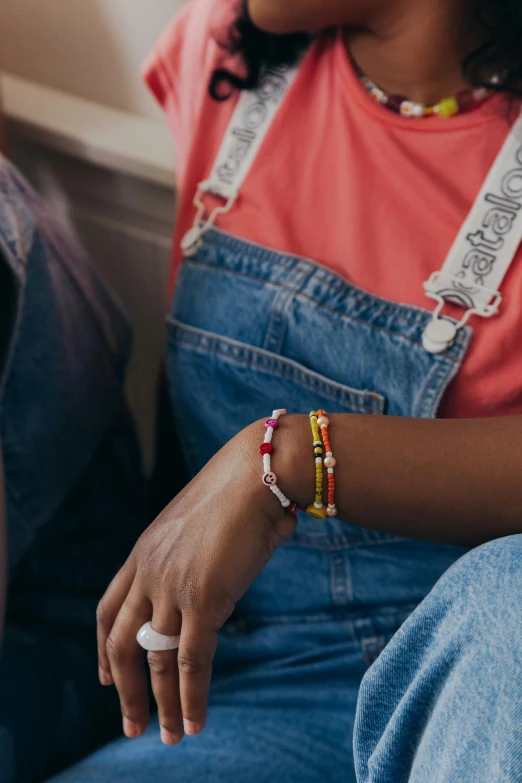 someone with a celet on their wrist sits on the sofa